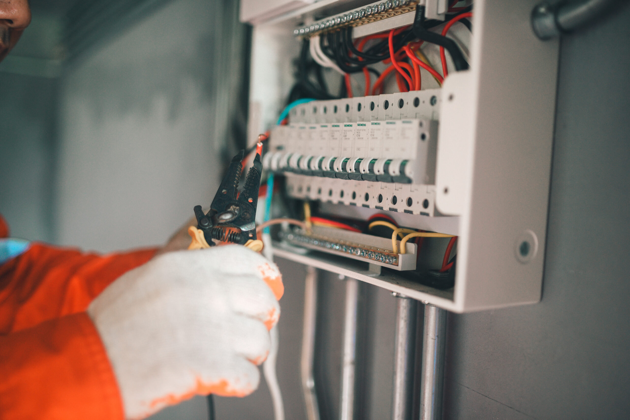 Side view of a handsome Asian electrician repairing an electrica