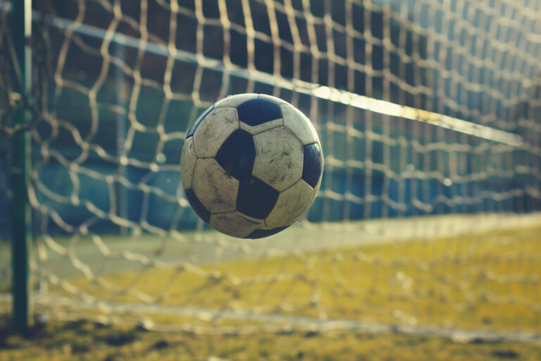 Soccer Ball Mid Air Near Goal with Vacant Stands