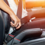 Asian woman fastening seat belt in the car, safety concept